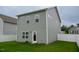 View of the backyard with a gray home exterior, green lawn, and white fence at 111 Flying Point Ln, Clayton, NC 27520