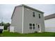 View of the backyard with a gray home exterior, green lawn, and white fence at 111 Flying Point Ln, Clayton, NC 27520