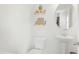 Bright white bathroom features floating shelves, round mirror, and pedestal sink at 111 Flying Point Ln, Clayton, NC 27520