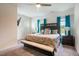 A sun-filled main bedroom features a king bed, bench, and ceiling fan at 111 Flying Point Ln, Clayton, NC 27520