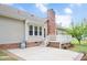 Backyard patio with brick chimney, steps to deck, and view of the home's exterior features at 1117 Country Brooke Dr, Raleigh, NC 27603