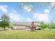 Expansive backyard view featuring the home's exterior, patio, mature trees, and well-manicured lawn at 1117 Country Brooke Dr, Raleigh, NC 27603