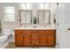Bathroom with double sink vanity, wood cabinets, and two framed mirrors above the sinks at 1117 Country Brooke Dr, Raleigh, NC 27603