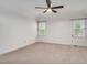 Bright bedroom featuring neutral carpet, a ceiling fan, and natural light from two windows at 1117 Country Brooke Dr, Raleigh, NC 27603