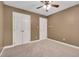 Bedroom with a ceiling fan, neutral carpet, and two white closets at 1117 Country Brooke Dr, Raleigh, NC 27603