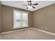 Bedroom with tan walls, neutral carpet, and a ceiling fan with a window overlooking outside at 1117 Country Brooke Dr, Raleigh, NC 27603