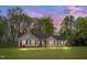 Charming single-story home with a well-manicured lawn and mature trees in a peaceful neighborhood at twilight at 1117 Country Brooke Dr, Raleigh, NC 27603