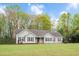 Well-maintained one-story home with a lush green lawn, mature trees, and classic shutters at 1117 Country Brooke Dr, Raleigh, NC 27603