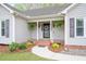 Inviting front entrance with decorative wreath, hanging ferns, and freshly landscaped flowerbeds leading to front door at 1117 Country Brooke Dr, Raleigh, NC 27603