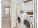 Laundry room with washer, dryer, ironing board, and folding door to bedroom at 1117 Country Brooke Dr, Raleigh, NC 27603