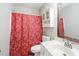 A bathroom featuring a toilet, sink with vanity, mirror, and a red patterned shower curtain at 116 Marlowe Court Ct, Carrboro, NC 27510
