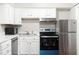 Bright kitchen features stainless steel appliances, white cabinets, and light countertops at 116 Marlowe Court Ct, Carrboro, NC 27510
