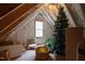 Attic featuring wooden rafters, exposed insulation, a window, and a Christmas tree at 125 Dartmoor Ln, Raleigh, NC 27614