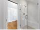 Bathroom featuring a glass shower, a bench, stone floors, and access to the hallway at 125 Dartmoor Ln, Raleigh, NC 27614
