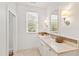 Bright bathroom features a window, vanity with marble countertop, and chrome fixtures at 125 Dartmoor Ln, Raleigh, NC 27614