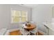 Cozy dining area featuring a round wood table, white chairs, hardwood floors, and a window at 125 Dartmoor Ln, Raleigh, NC 27614