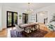 Elegant dining room featuring hardwood floors, stylish chandelier, and black french doors at 125 Dartmoor Ln, Raleigh, NC 27614