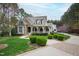 Beautiful home featuring a brick driveway, lush landscaping, and a charming stone and shingle facade at 125 Dartmoor Ln, Raleigh, NC 27614