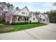 Beautiful white home with a covered porch, lush green lawn, and a driveway with brick accents at 125 Dartmoor Ln, Raleigh, NC 27614