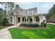 Stunning home featuring a stone facade, shingle roofing, and a welcoming front porch at 125 Dartmoor Ln, Raleigh, NC 27614