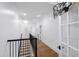 Bright hallway features hardwood floors, white walls, and staircase with black railings at 125 Dartmoor Ln, Raleigh, NC 27614