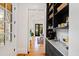 Hallway with dark built-in shelving, leading to a dining area with hardwood floors and a view of the exterior at 125 Dartmoor Ln, Raleigh, NC 27614