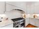 Close-up of a kitchen with a stainless steel gas range, granite countertops, and herringbone backsplash at 125 Dartmoor Ln, Raleigh, NC 27614