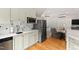 Kitchen area featuring white cabinets, stainless steel appliances, and hardwood floors at 125 Dartmoor Ln, Raleigh, NC 27614