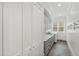 Bright laundry room with gray cabinets, white countertop, and a window with natural light at 125 Dartmoor Ln, Raleigh, NC 27614