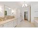 Bright primary bathroom featuring double vanity, soaking tub, large mirror and a walk-in closet at 125 Dartmoor Ln, Raleigh, NC 27614