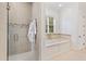 Tiled main bathroom featuring separate shower and soaking tub, with a large window bringing in natural light at 125 Dartmoor Ln, Raleigh, NC 27614