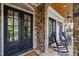 Inviting front porch with stone flooring, comfortable seating, and stylish ceiling fans at 125 Dartmoor Ln, Raleigh, NC 27614