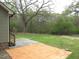 Large backyard featuring an orange tiled patio, spacious lawn, mature trees, and a chain-link fence at 126 Creedmoor Rd, Stem, NC 27581