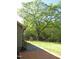 Landscaped backyard with a large tree, patio, and play set, perfect for outdoor activities at 126 Creedmoor Rd, Stem, NC 27581