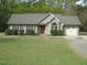Charming single-story home with well-maintained lawn, shrubs, a red front door, and a two-car garage at 126 Creedmoor Rd, Stem, NC 27581