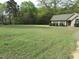 Spacious front yard with lush green grass, a well-maintained lawn, and mature trees at 126 Creedmoor Rd, Stem, NC 27581