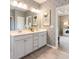 Well-lit bathroom featuring a double vanity, decorative wallpaper, and an open doorway at 1260 Hazelnut Ridge Ln, Knightdale, NC 27545