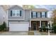 Charming two-story home featuring a garage, stone accents and a covered front porch with rocking chairs at 1620 Frog Hollow Way, Wake Forest, NC 27587