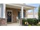 Cozy covered front porch with rocking chairs, stone accents, and a decorative front door wreath at 1620 Frog Hollow Way, Wake Forest, NC 27587