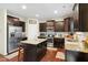 Spacious kitchen boasting stainless appliances, tile backsplash, granite counters, center island, dark cabinets and hardwood flooring at 1620 Frog Hollow Way, Wake Forest, NC 27587