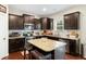 Beautiful kitchen featuring dark cabinets, stainless steel appliances, granite countertops and center island with barstool seating at 1620 Frog Hollow Way, Wake Forest, NC 27587