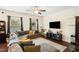 Spacious living room with a sectional couch, ceiling fan, and decorative shelving at 1620 Frog Hollow Way, Wake Forest, NC 27587