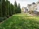 Spacious backyard with lush green lawn, mature trees, and a charming patio area at 1625 Heritage Garden St, Wake Forest, NC 27587