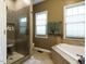 Elegant bathroom featuring a walk-in shower and a soaking tub with natural light at 1625 Heritage Garden St, Wake Forest, NC 27587