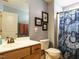 Functional bathroom with a wooden vanity, decorative shower curtain and neutral wall color at 1625 Heritage Garden St, Wake Forest, NC 27587