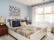 Cozy bedroom featuring a bed with decorative pillows and a patterned quilt, bathed in natural light at 1625 Heritage Garden St, Wake Forest, NC 27587