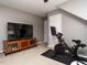 Exercise room with equipment, TV, and storage, perfect for staying active at home at 1625 Heritage Garden St, Wake Forest, NC 27587