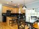 Open kitchen layout with wood cabinets, black countertops and appliances, and adjacent dining area at 1625 Heritage Garden St, Wake Forest, NC 27587
