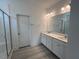 A pristine bathroom featuring double sinks and a glass-enclosed shower at 163 Little Creek Dr, Lillington, NC 27546