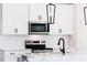 A close up of a well-lit kitchen with white cabinets and stainless steel appliances at 163 Little Creek Dr, Lillington, NC 27546